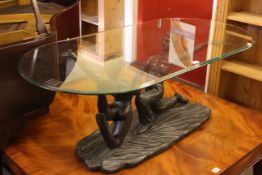 Oval glass topped coffee table with dancing figural base