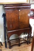 Antique walnut cabinet on stand having frieze drawer above two cupboard doors enclosing a series of