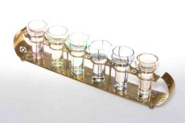 Set of six shot glasses on brass Arts and Crafts stand