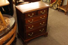 Small mahogany four height chest with brass drop handles on bracket feet