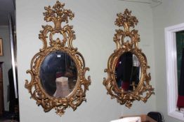 Pair of elaborate gilt girandole mirrors, 116.