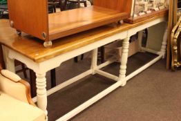 Long polished top side table with cream painted turned legs and understretchers,