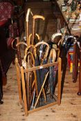 Assorted walking sticks, split cane fishing rod, brollies,