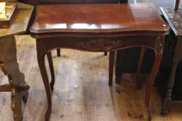 Victorian mahogany foldover card table, carved with foliage and raised on cabriole legs,