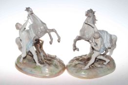 Pair of Continental porcelain groups of a male figure and rearing horse, underglaze blue PF mark,