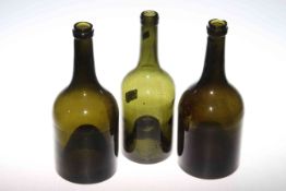 Three green glass bottles with inverted bases,