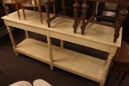 Cream finished buffet style table raised on six reeded and turned legs with undershelf,