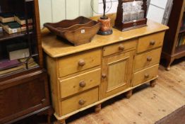 Pine dresser having central drawer above a cupboard door flanked by two banks of three drawers,