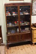 1920's mahogany cabinet bookcase having two glazed panel doors above two cupboard doors on ball and