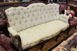 Victorian style settee with scroll carved rail and deep buttoned back