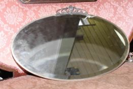 Art Deco oval mirror with metal frame and stylised crest,