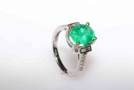 18 carat gold, oval emerald ring with baguette and round brilliant diamond shoulders,