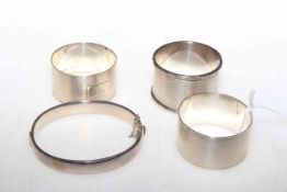 Three silver napkin rings and bangle (4)