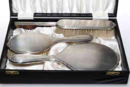Silver engine-turned four piece brush, comb and mirror set,