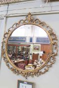 Ornate circular gilt framed bevelled wall mirror