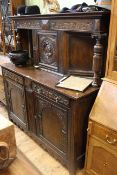 Early 20th Century carved oak court cupboard having turned pillars and portrait panel door above
