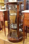 Polished wood cylindrical display cabinet with two adjustable glass shelves,