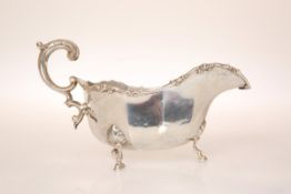A GEORGE V SILVER SAUCE BOAT, London 1930, the scrolling handle with acanthus cast thumbpiece,