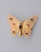 A SAPPHIRE AND RUBY SET BROOCH, modelled as a butterfly, the wings with multi cut-out detailing,