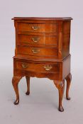 A WALNUT CHEST IN THE FORM OF A TALLBOY, bow-fronted, the upper section with three drawers,