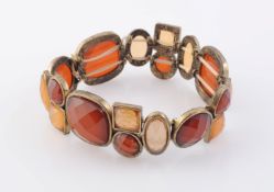 A RED AND ORANGE COLOURED STONE BRACELET, possibly carnelian, of alternating oval,