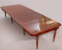 AN EARLY 19TH CENTURY MAHOGANY DINING TABLE, extending to approximately 12-feet,