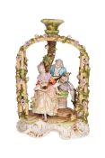 A CONTINENTAL PORCELAIN ARBOUR GROUP, modelled as a gentleman serenading a young lady holding a fan,