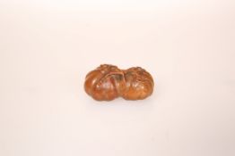 A JAPANESE WOOD NETSUKE, carved as persimmon fruit.