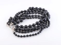 A JET BEAD NECKLACE, formed of five graduating polished and faceted black beads,