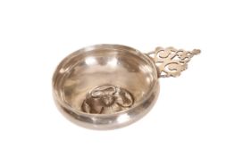 A LARGE CONTINENTAL WHITE METAL TASTE VIN, with pierced scroll handle,