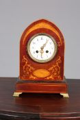 AN EDWARDIAN INLAID MAHOGANY MANTEL CLOCK, the circular dial with Arabic numerals and floral swags,