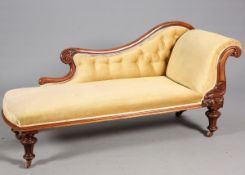 A VICTORIAN MAHOGANY CHAISE LONGUE, with leaf-carved scroll-end raised on fluted baluster legs,