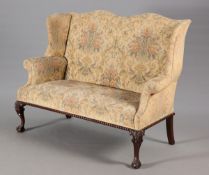 A CARVED MAHOGANY AND UPHOLSTERED WING-BACK SETTEE IN 18TH CENTURY STYLE, LATE 19TH CENTURY,