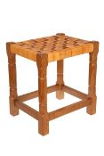 A SID POLLARD OAK STOOL, with leather strapwork seat and faceted legs continuing to blocks.