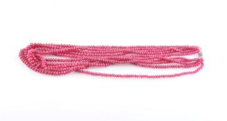 A RUBY BEAD NECKLACE, formed of five strands of graduating ruby bead highlights,