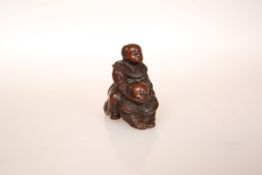 A JAPANESE WOOD NETSUKE, carved as two boys playing piggy back, signed.