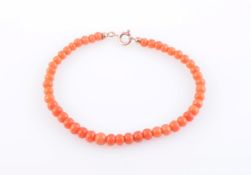 A CORAL BEAD BRACELET, the forty-seven uniform coral beads strung simply onto bolt ring clasp.
