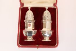 A PAIR OF GEORGE V SILVER PEPPER POTS, Goldsmiths & Silversmiths Co, London 1926, in a fitted case.