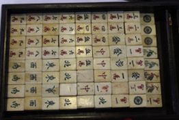 A CHINESE BONE MAHJONG SET, in a stained wooden box. Box 30cm by 19.