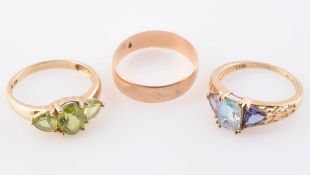 A COLLECTION OF THREE RINGS, one gold coloured wedding band. Ring size P; one set with peridots.