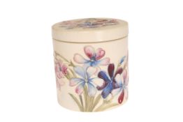 A MOORCROFT SALT-GLAZED JAR AND COVER IN THE SPRING FLOWERS PATTERN, cylindrical,