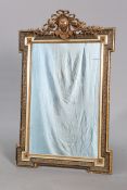 A 19TH CENTURY GILT-COMPOSITION MIRROR, of inverted rectangular form with ribbon-tied floral crest.