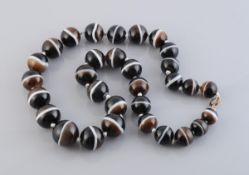 A BANDED AGATE NECKLACE, of thirty graduating polished banded agate beads,