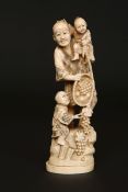 A LARGE JAPANESE IVORY OKIMONO, MEIJI PERIOD, carved as a father with two children and fruit,