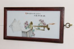A CHINESE PORCELAIN PLAQUE, painted with books and flowers by a flaming lamp,