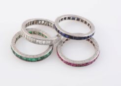 A SET OF FOUR ETERNITY RINGS, to include a ring set throughout with baguette cut diamonds.