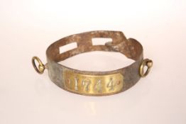 AN IRON SLAVE COLLAR, with applied brass plaque stamped 1744, two notches and two brass rings.
