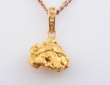 A GOLD NUGGET PENDANT, on a drop stamped 14K, the chain of base metal. Pendant 13.