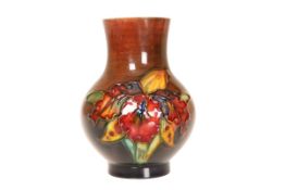 A SMALL MOORCROFT FLAMBE VASE, IN THE ORCHID PATTERN, of baluster form, impressed marks.