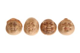 A SET OF FOUR SMALL ORIENTAL POTTERY MASKS OF SMILING MALE FIGURES, probably early 20th century,